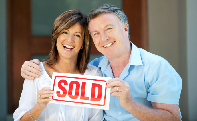 Couple with sold sign